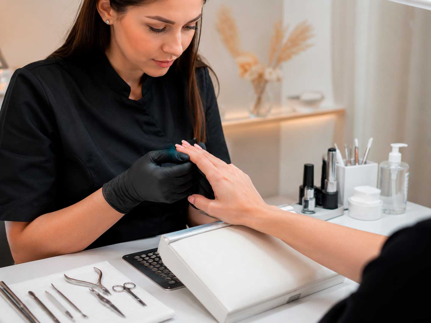 Manicure observa alteração nas unhas antes de iniciar o atendimento