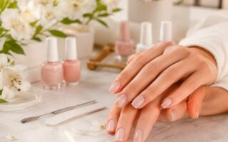 Unhas claras e delicadas com esmaltação nude rosada em ambiente elegante