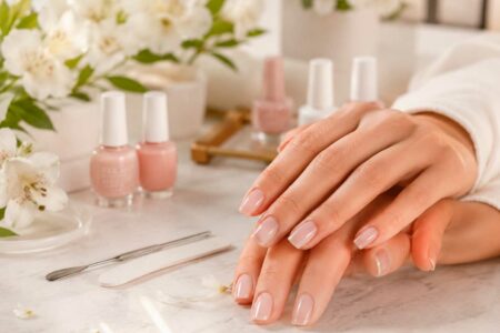 Unhas claras e delicadas com esmaltação nude rosada em ambiente elegante
