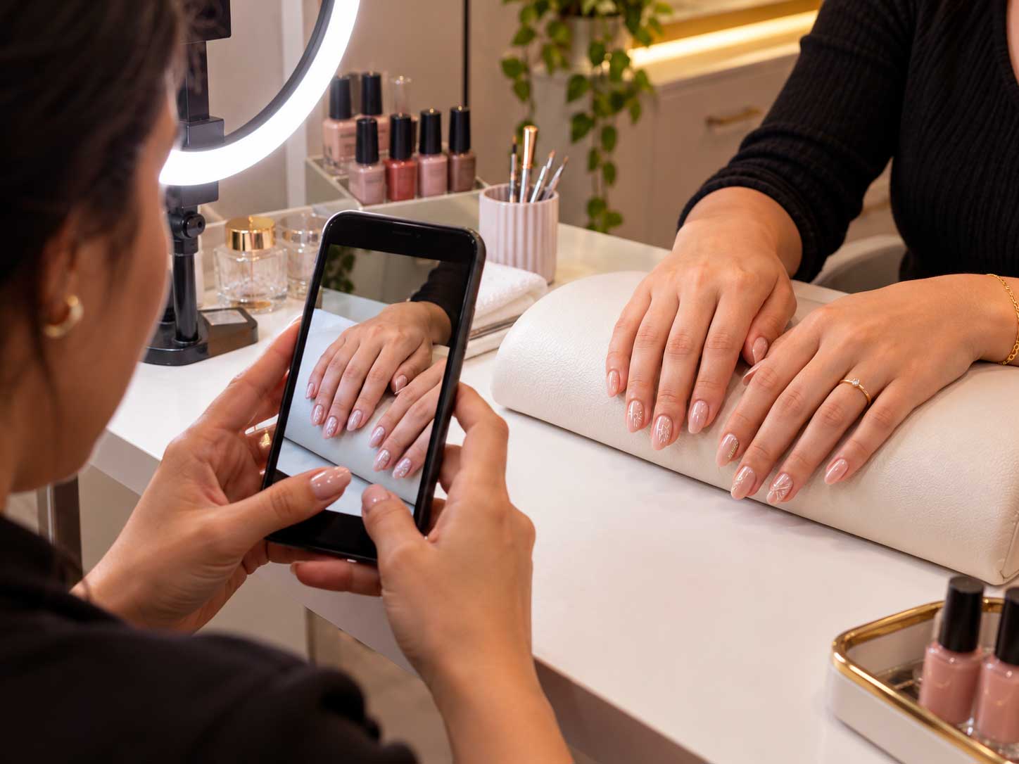 Manicure fotografando unhas decoradas para publicar seu trabalho nas redes sociais